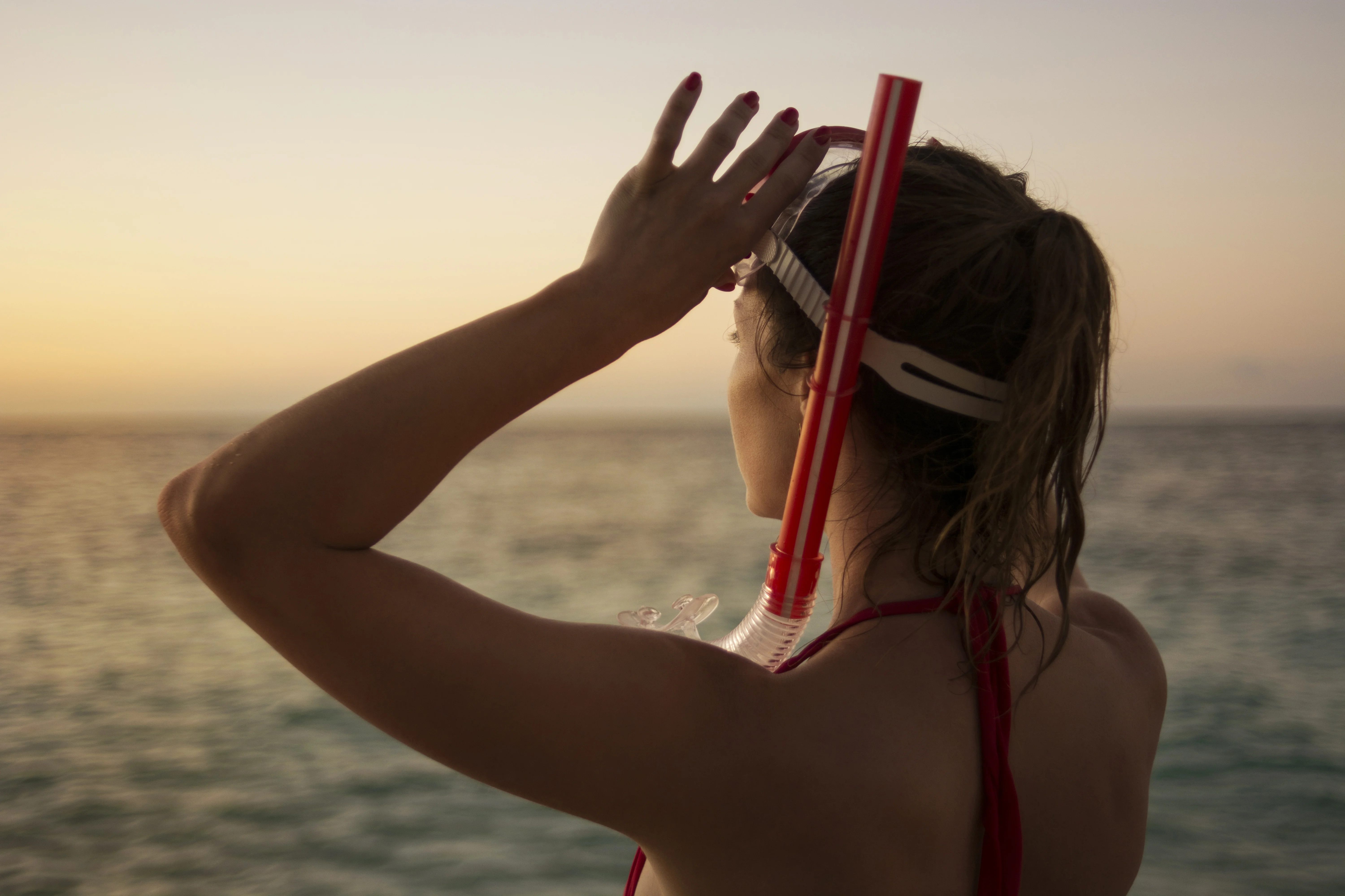 Snorkeler checking mask before entering Antigua water