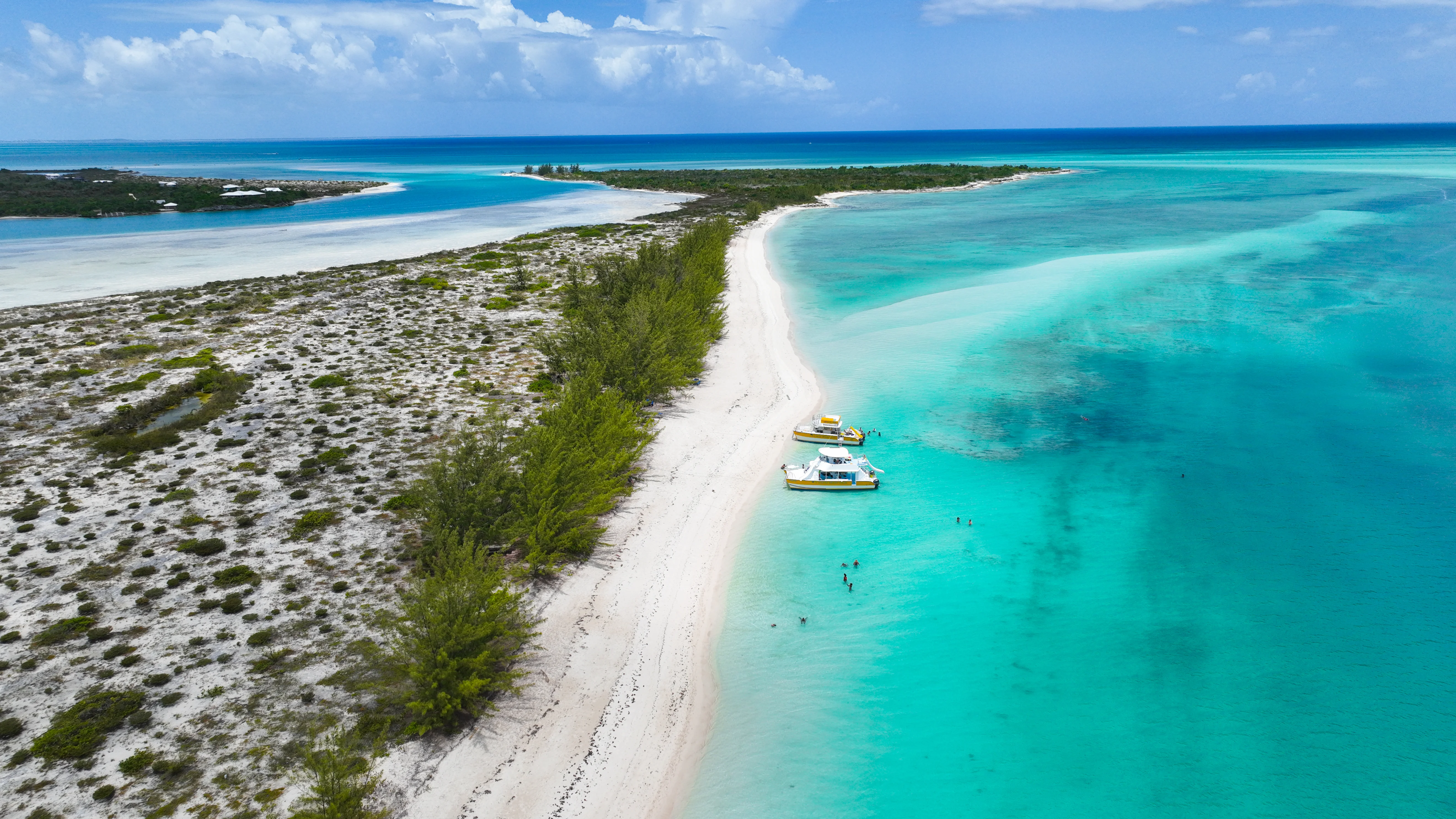 Catamaran sailing in clear blue ocean water near small uninhabited cays, Providenciales, Turks and Caicos