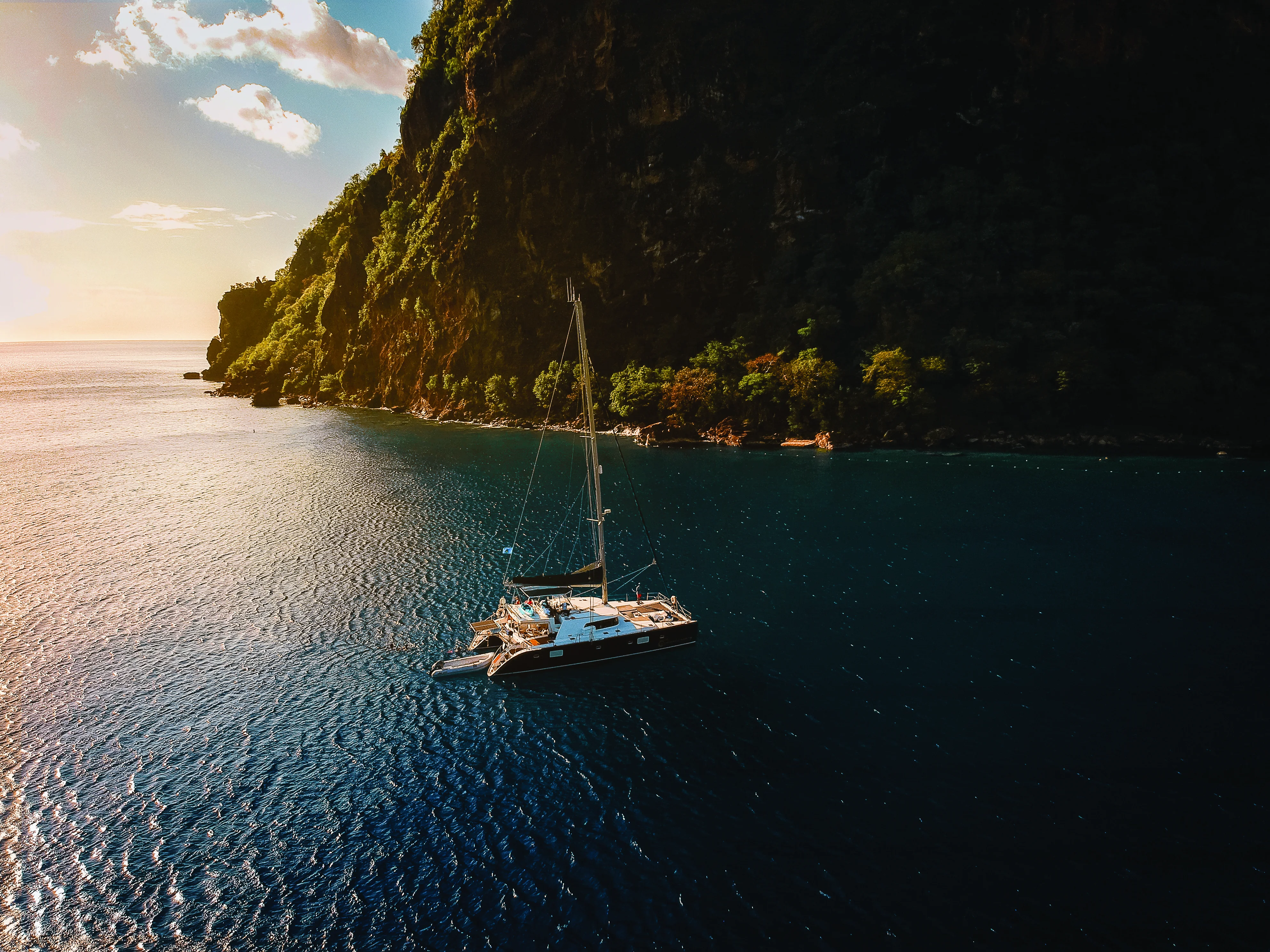 A catamaran sailing through turquoise Caribbean water