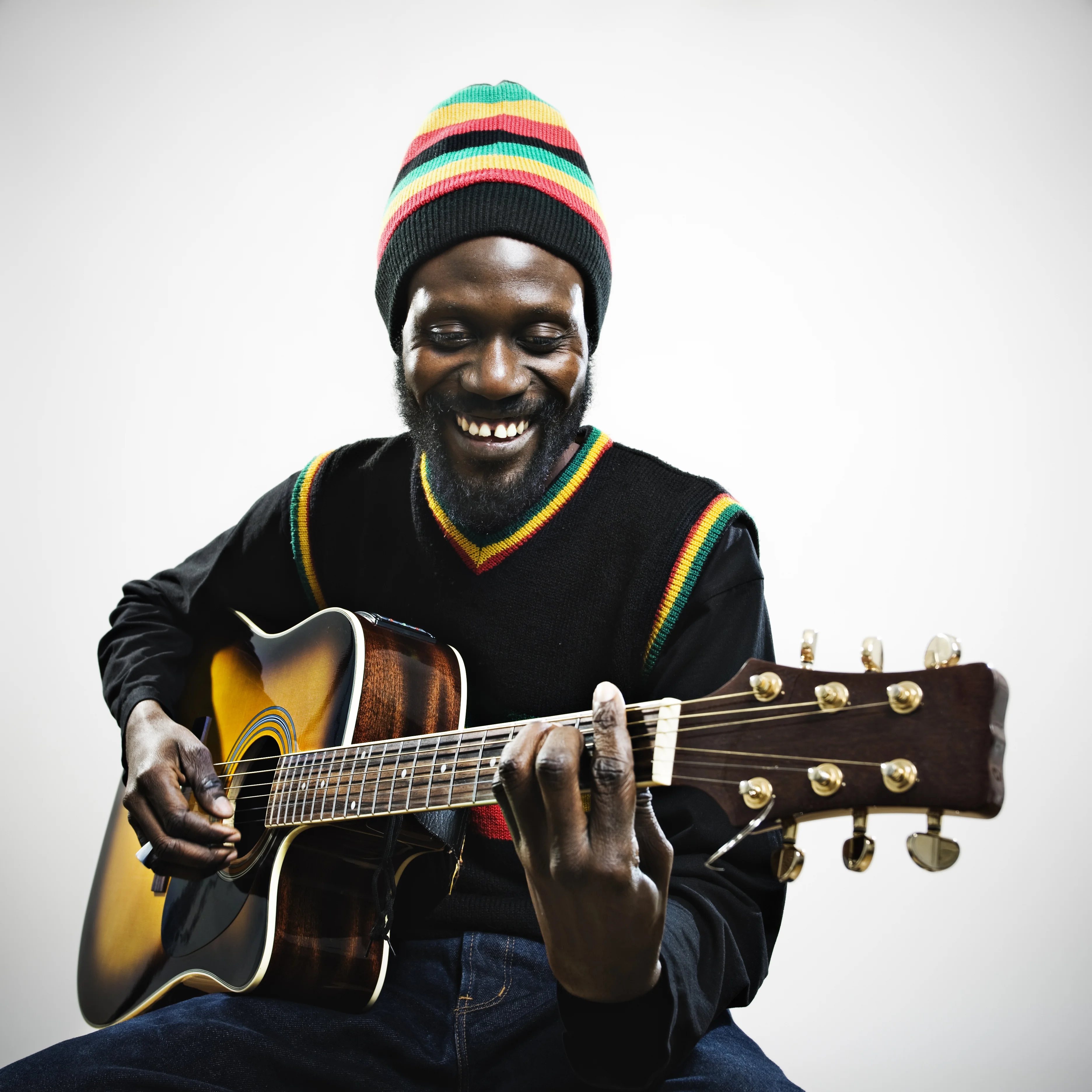 Jamaican artist with locks playing guitar